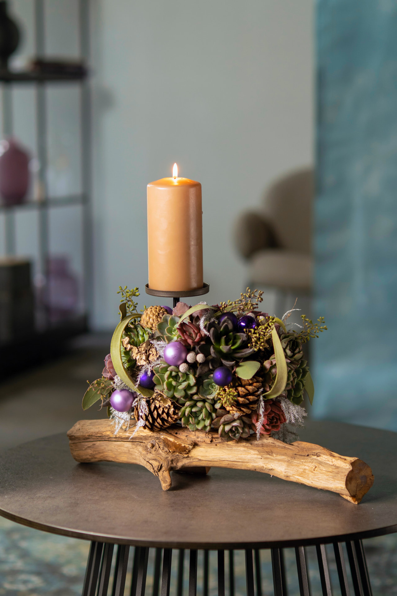 Festive Wincx succulent centerpiece with candle and purple ornaments
